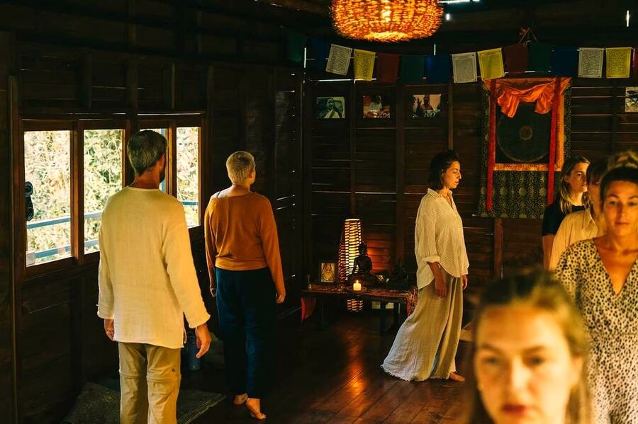 Group practice in the meditation hall with prayer flags