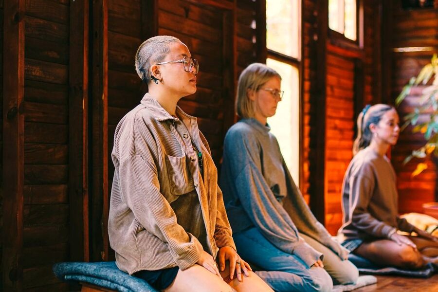 Group meditation session seated in a row by the window