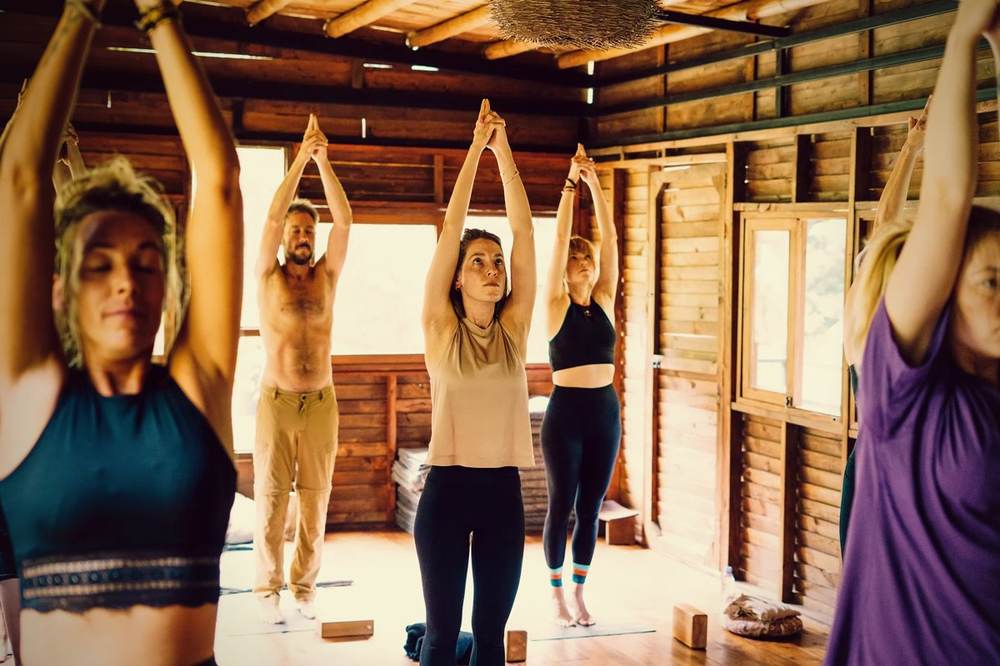 Group yoga class with arms raised